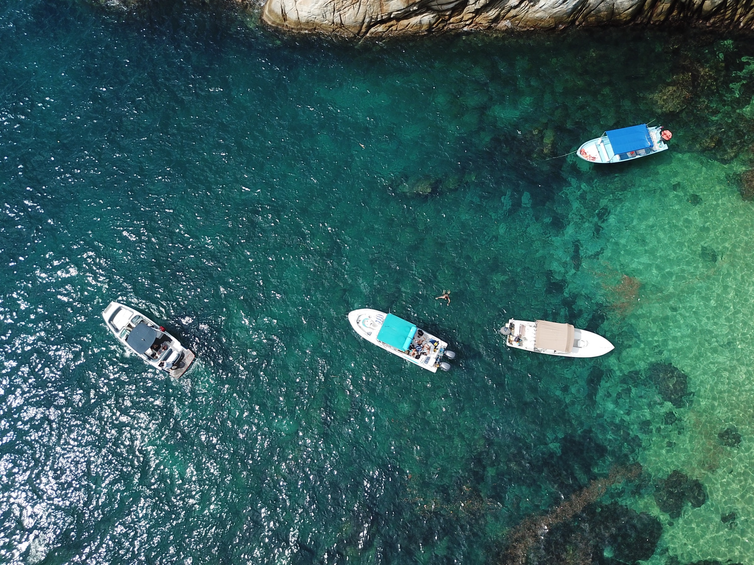 Vista aérea de embarcaciones sobre aguas turquesas en Bahía de Banderas.